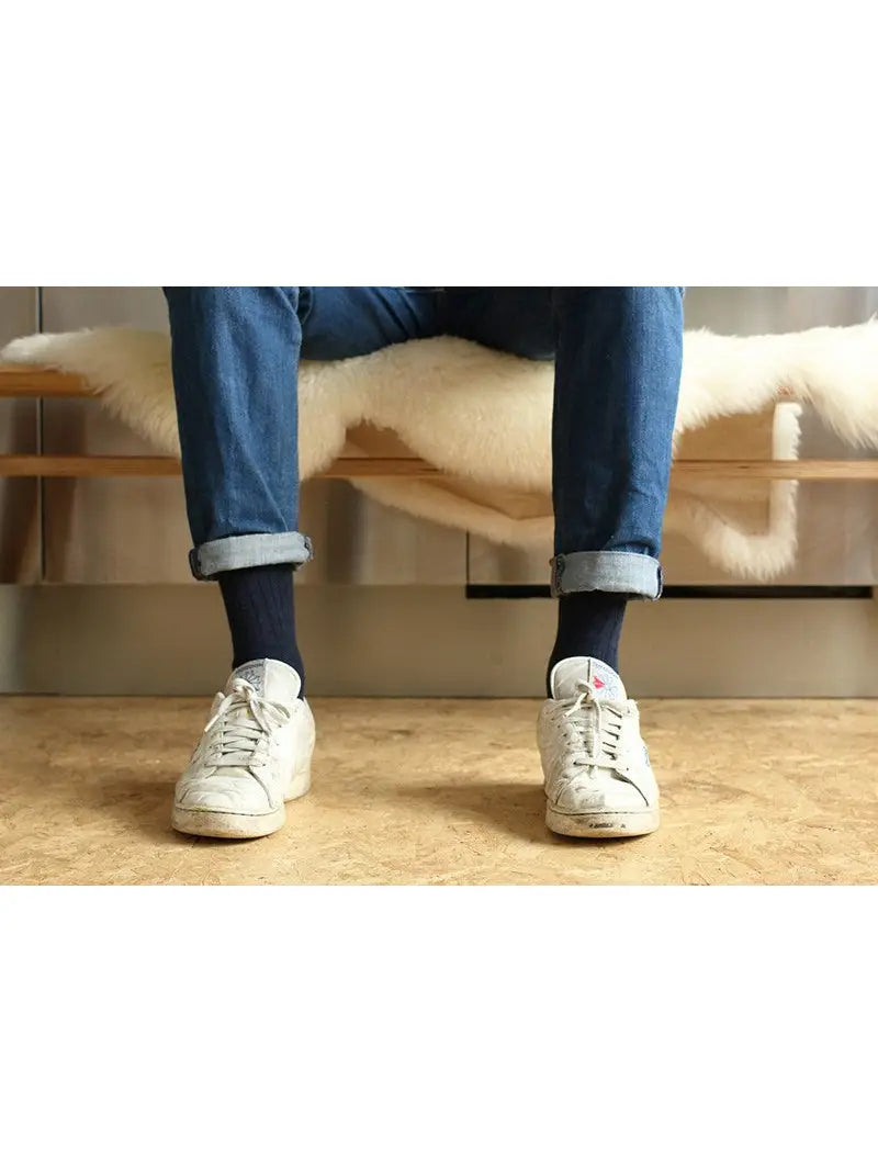 Man in jeans and sneakers wearing blue Escuyer Cashmere Wool Socks