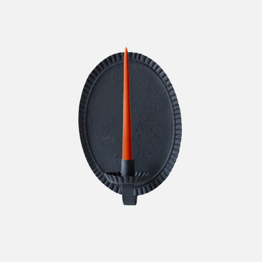Oval candle sconce with orange candle against grey background