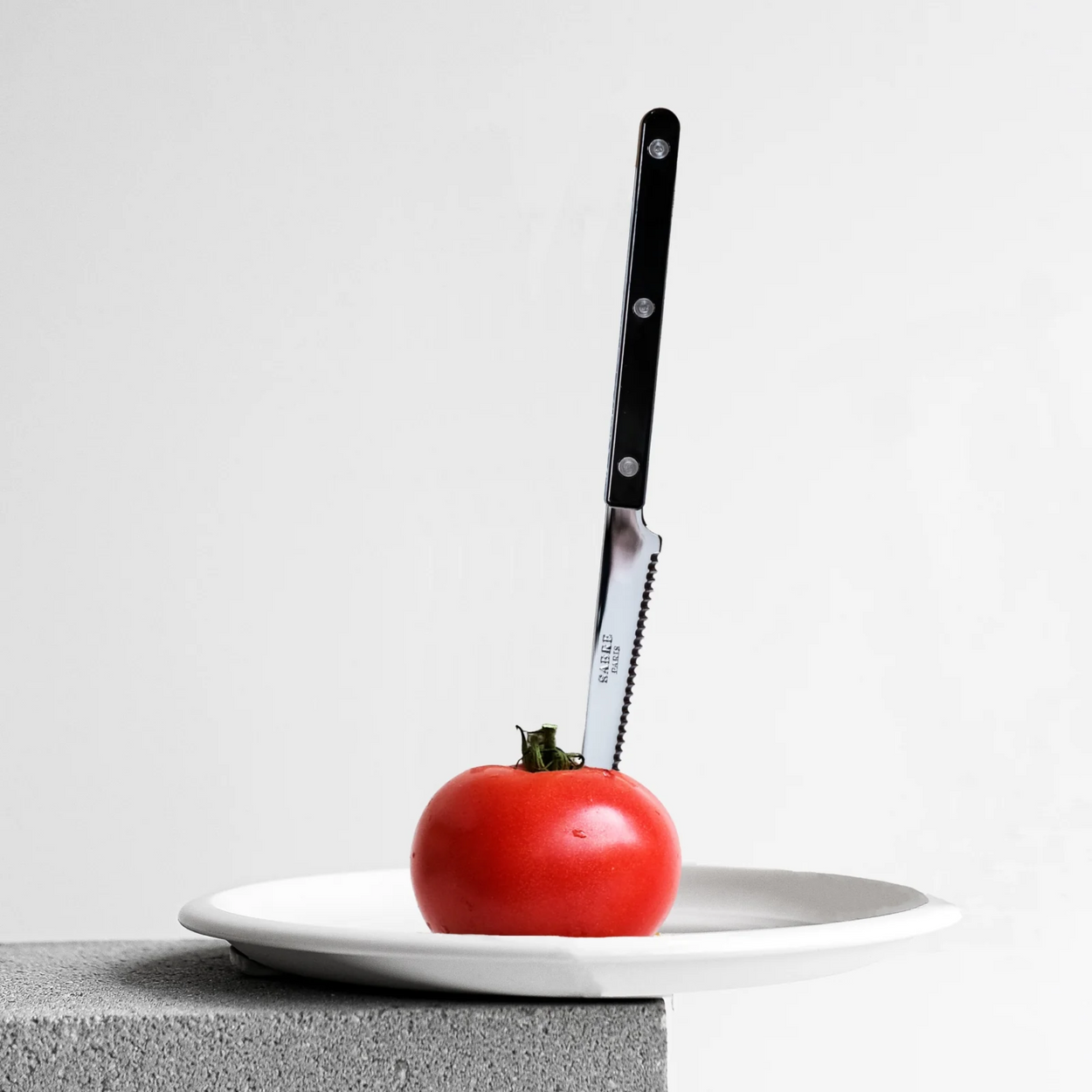 Black Sabre Paris Bistrot French Tomato Knife in tomato on white plate