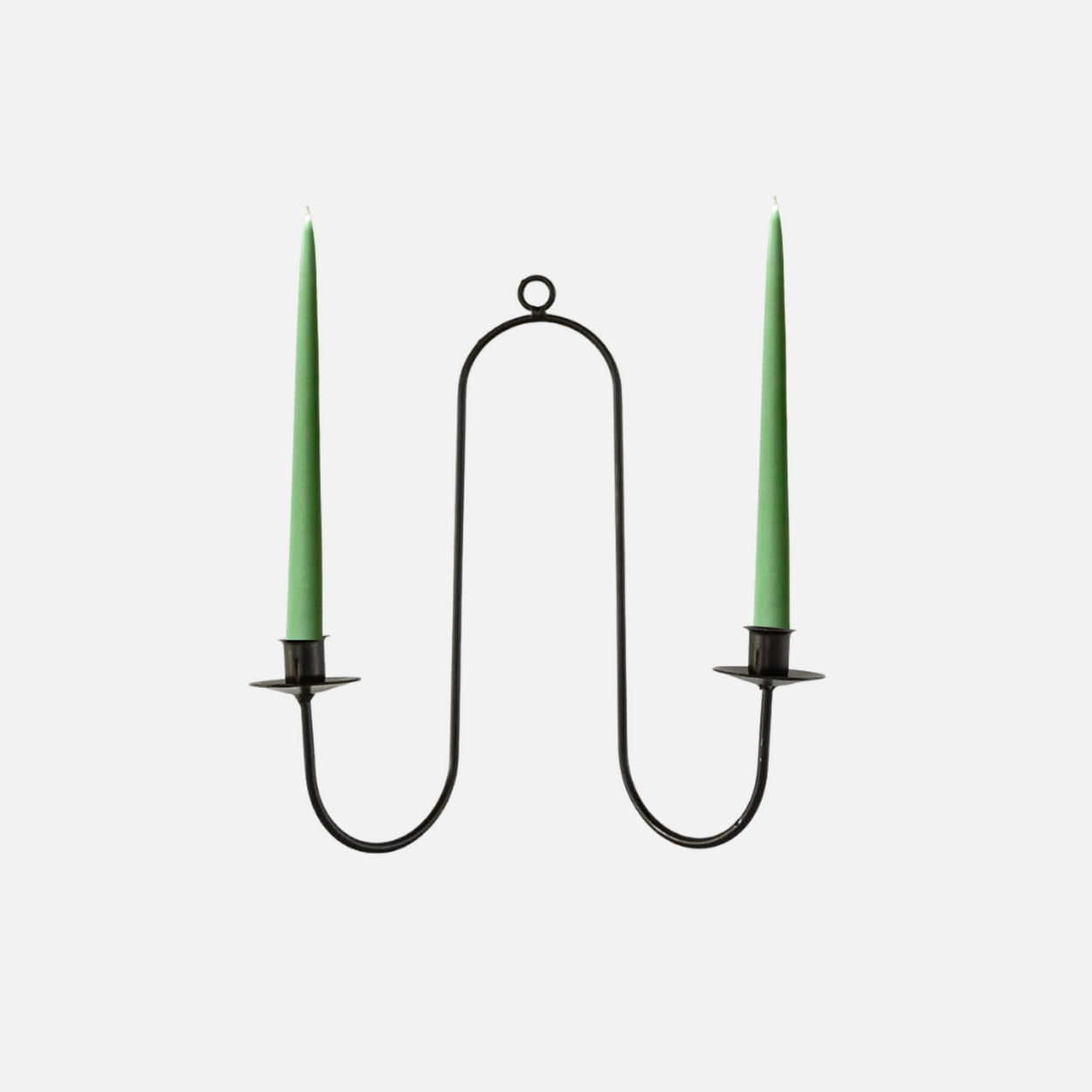 Black metal candle holder with two green candles on a white background