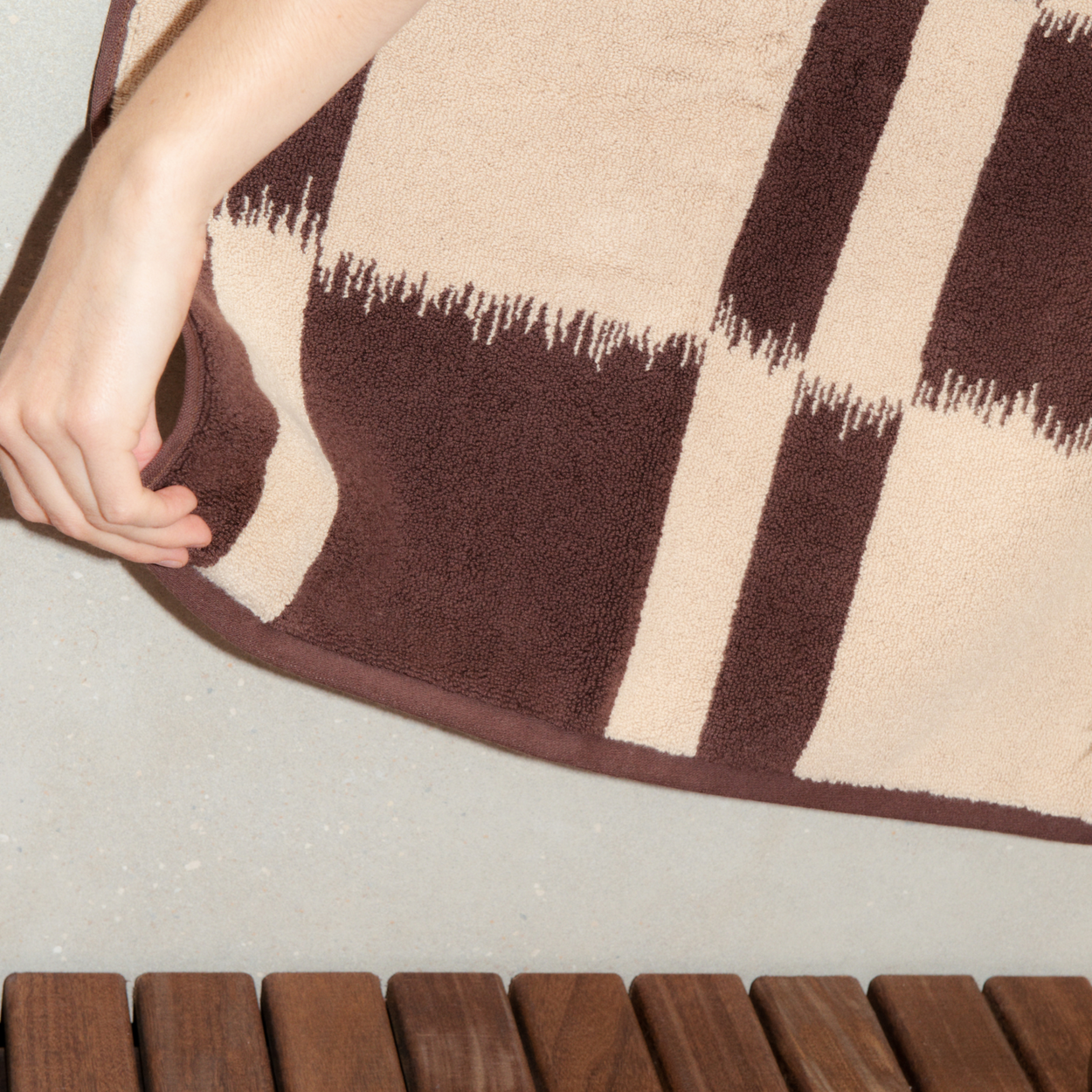 Woman with Autumn Sonata Karin Bath towel draped with hand holding corner.