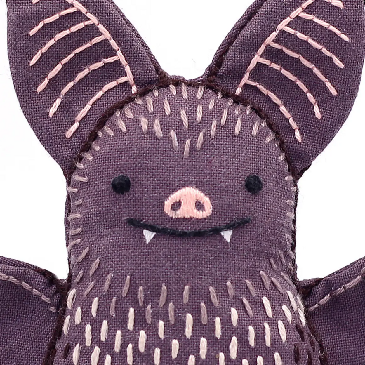 Purple bat plush toy with a smiling face on a white background
