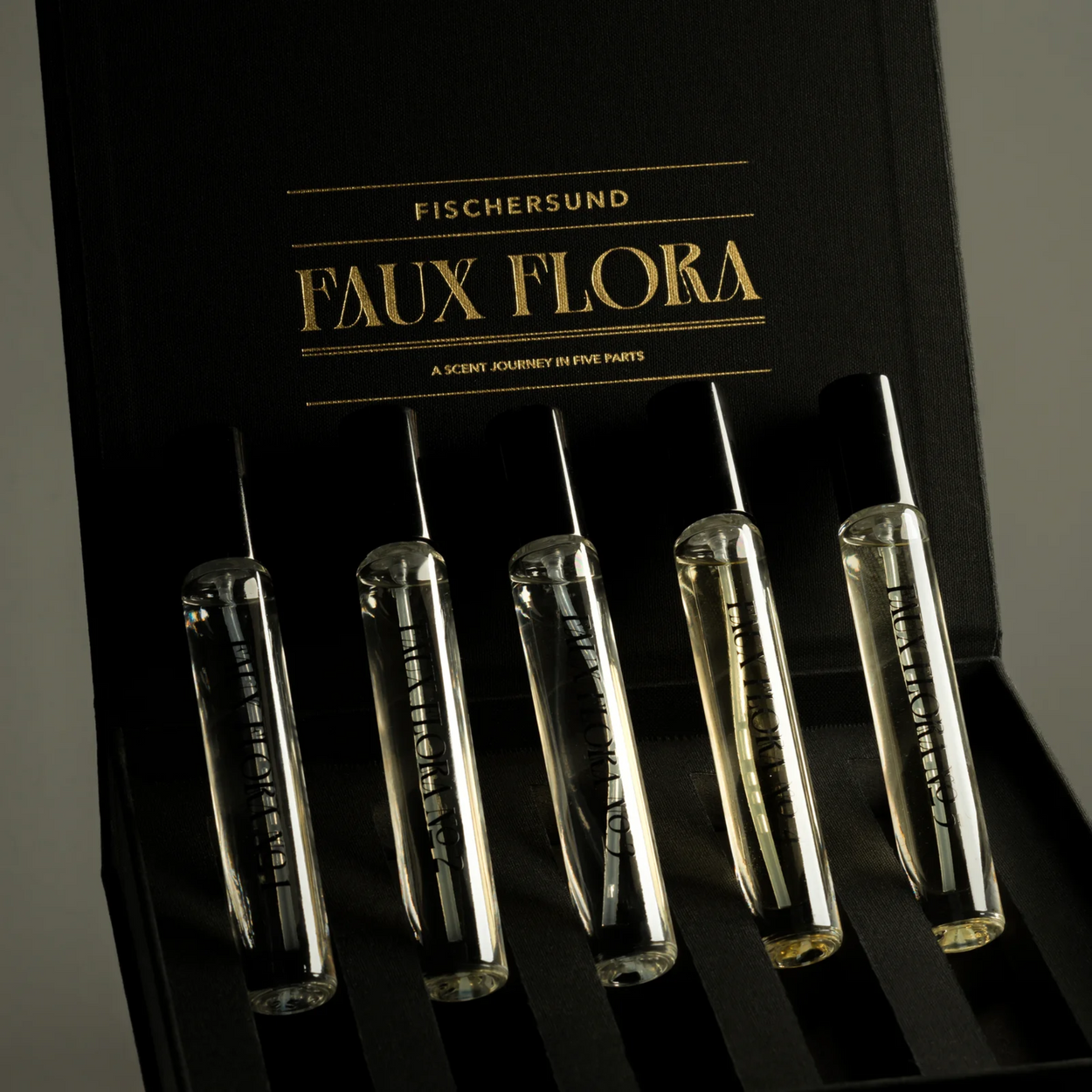 Set of clear vials with labels on a black background, featuring 'Fischersund Faux Flora' branding.