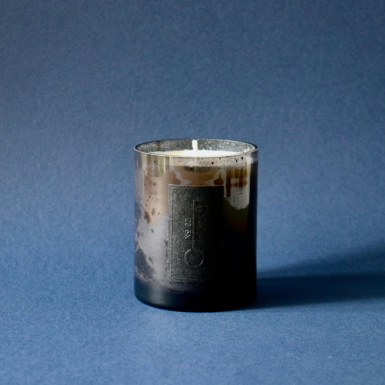 Fischersund No.23 candle against blue background.