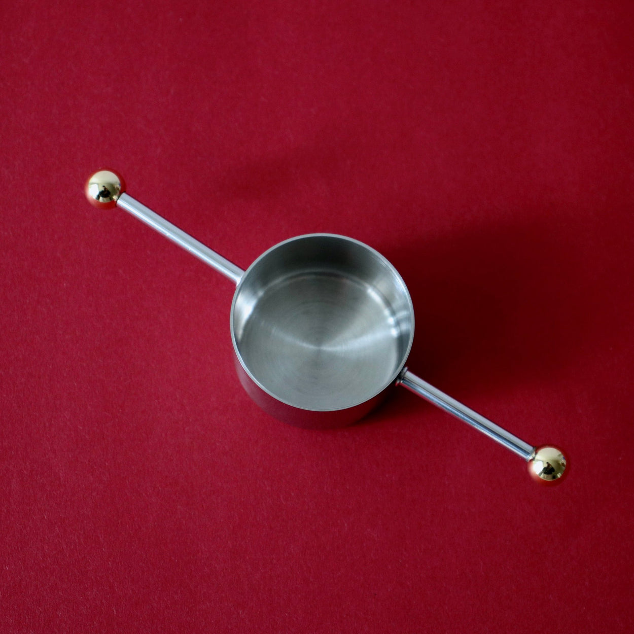 Japanese Cocktail Jigger against a red backdrop.