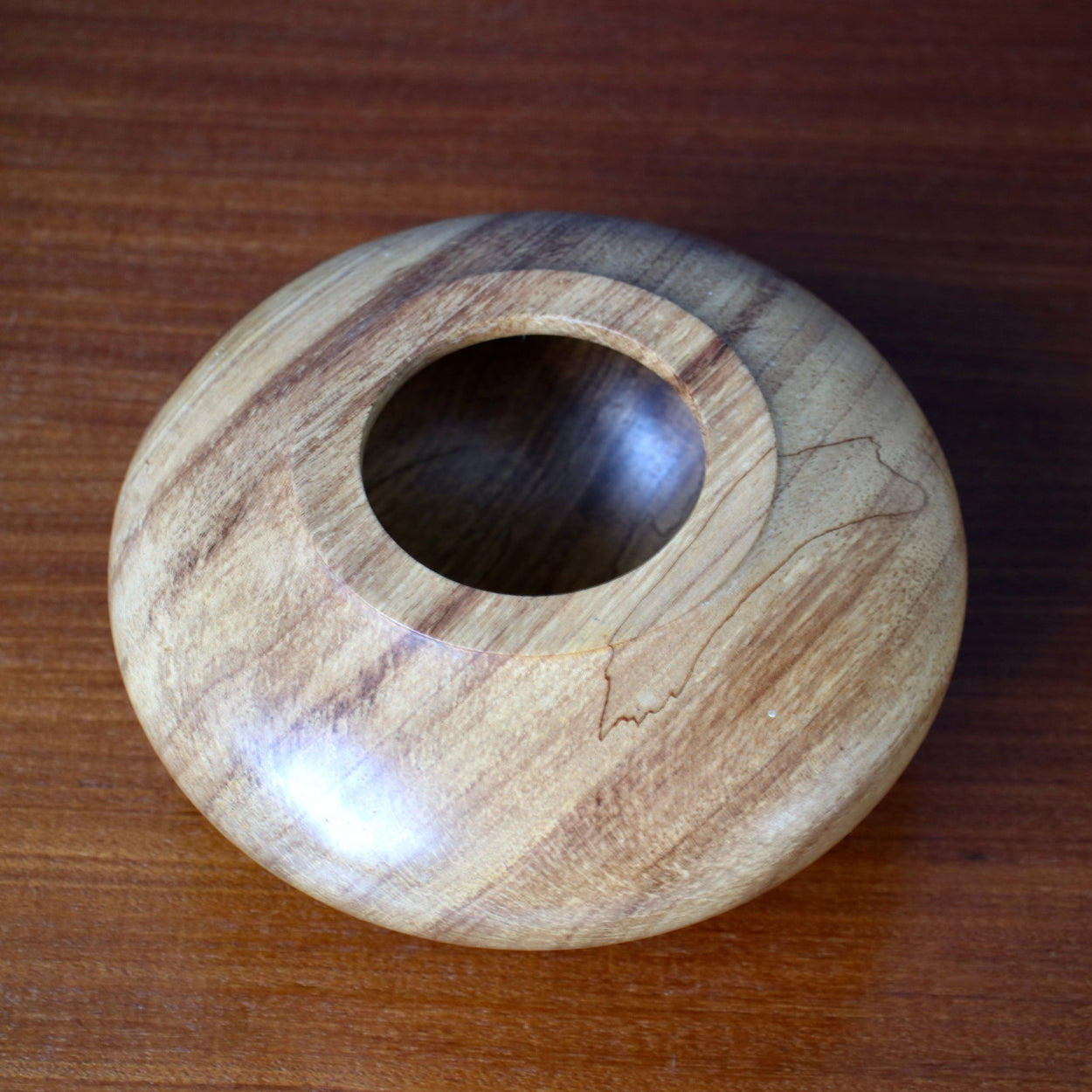 View from aove of Vintage wood low vase on wood table.