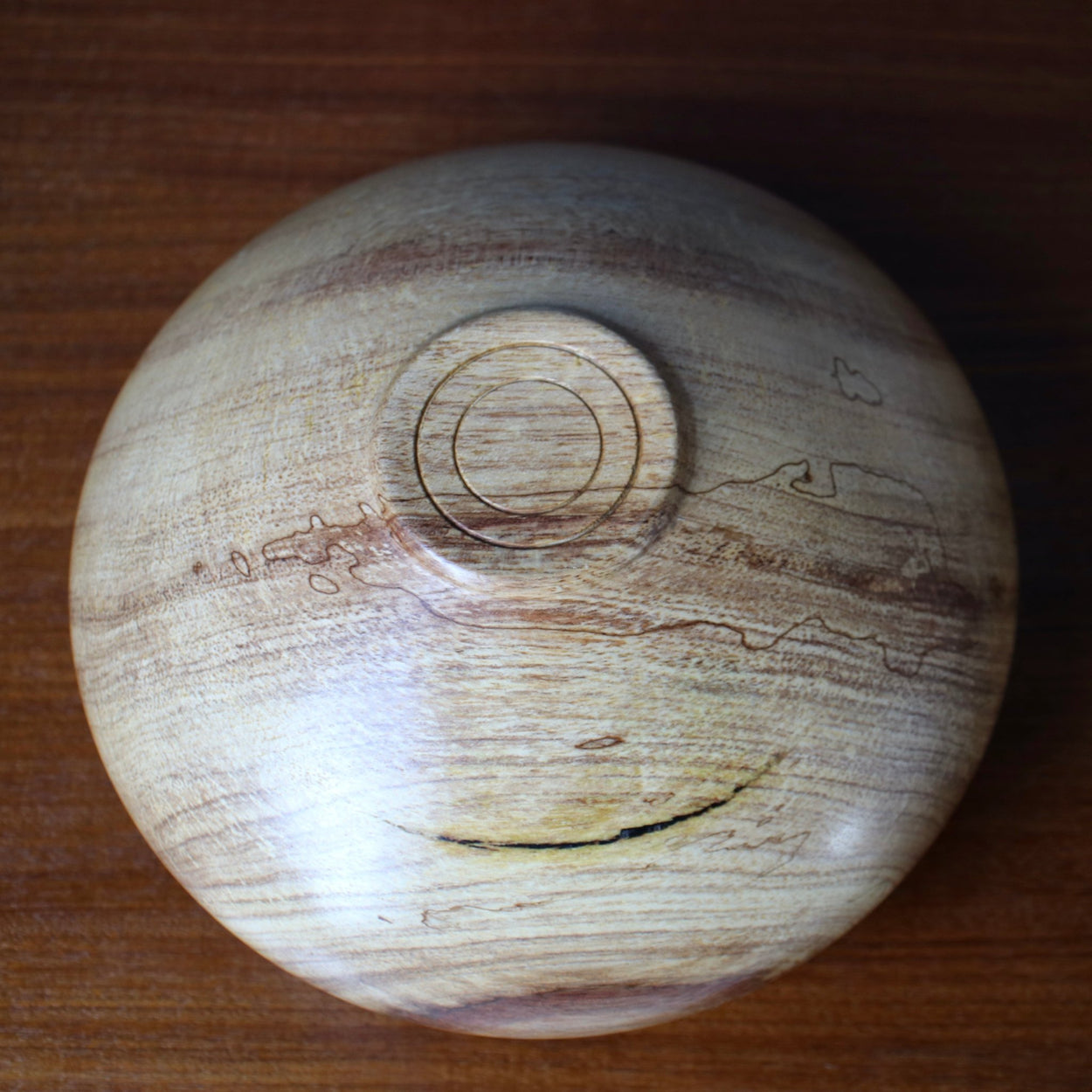 Base view of Vintage wood low vase on wood table.