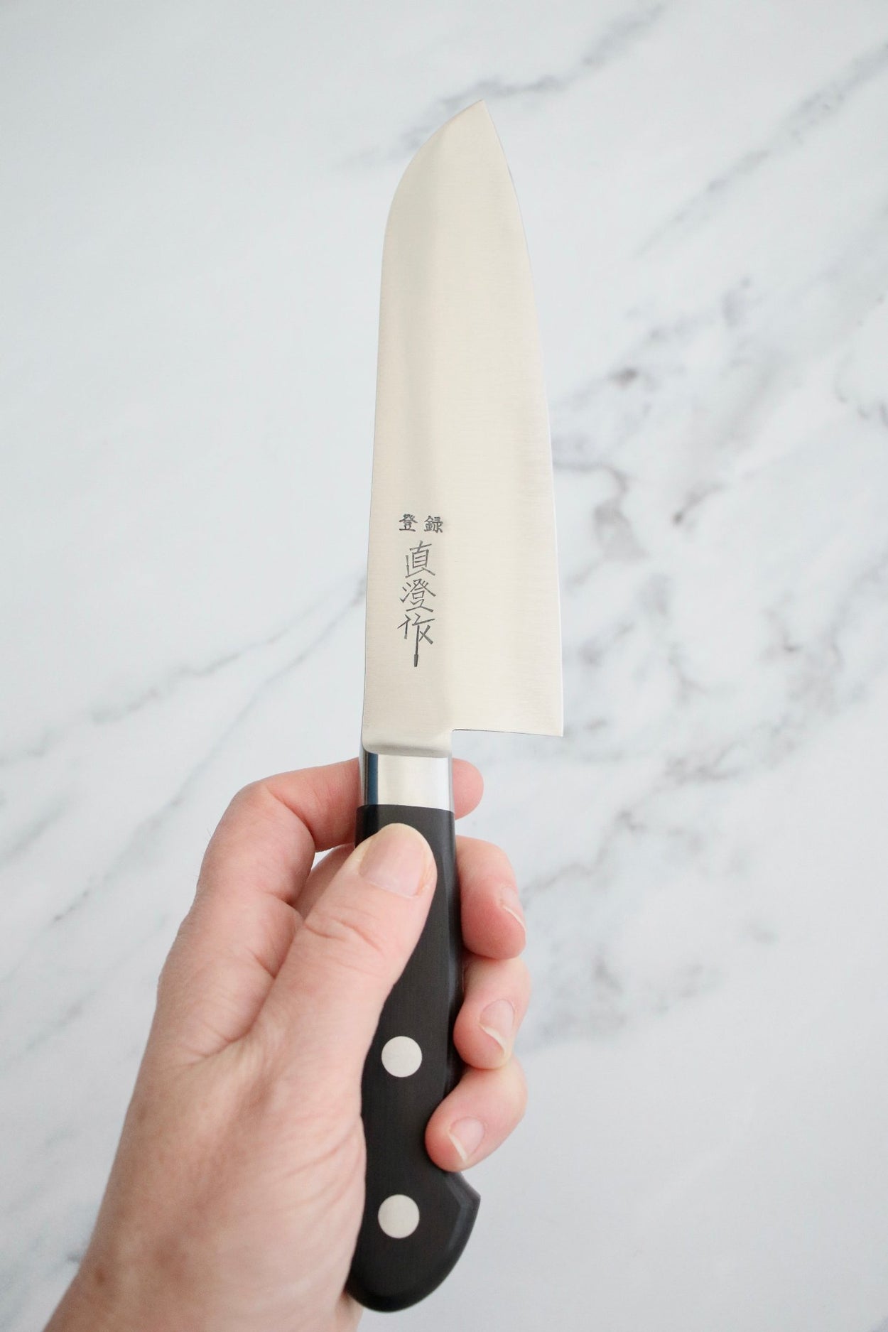 Japanese Naozumi Nihonkou 165mm Santoku Carbon Steel Kitchen Knife on marble background.