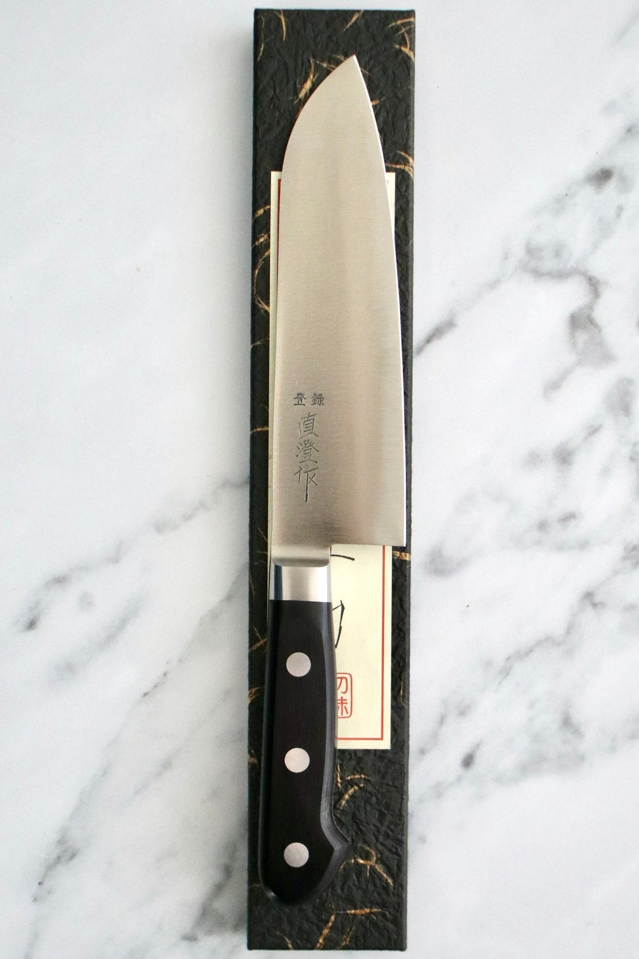 Japanese Naozumi Nihonkou 165mm Santoku Carbon Steel Kitchen Knife on marble background.