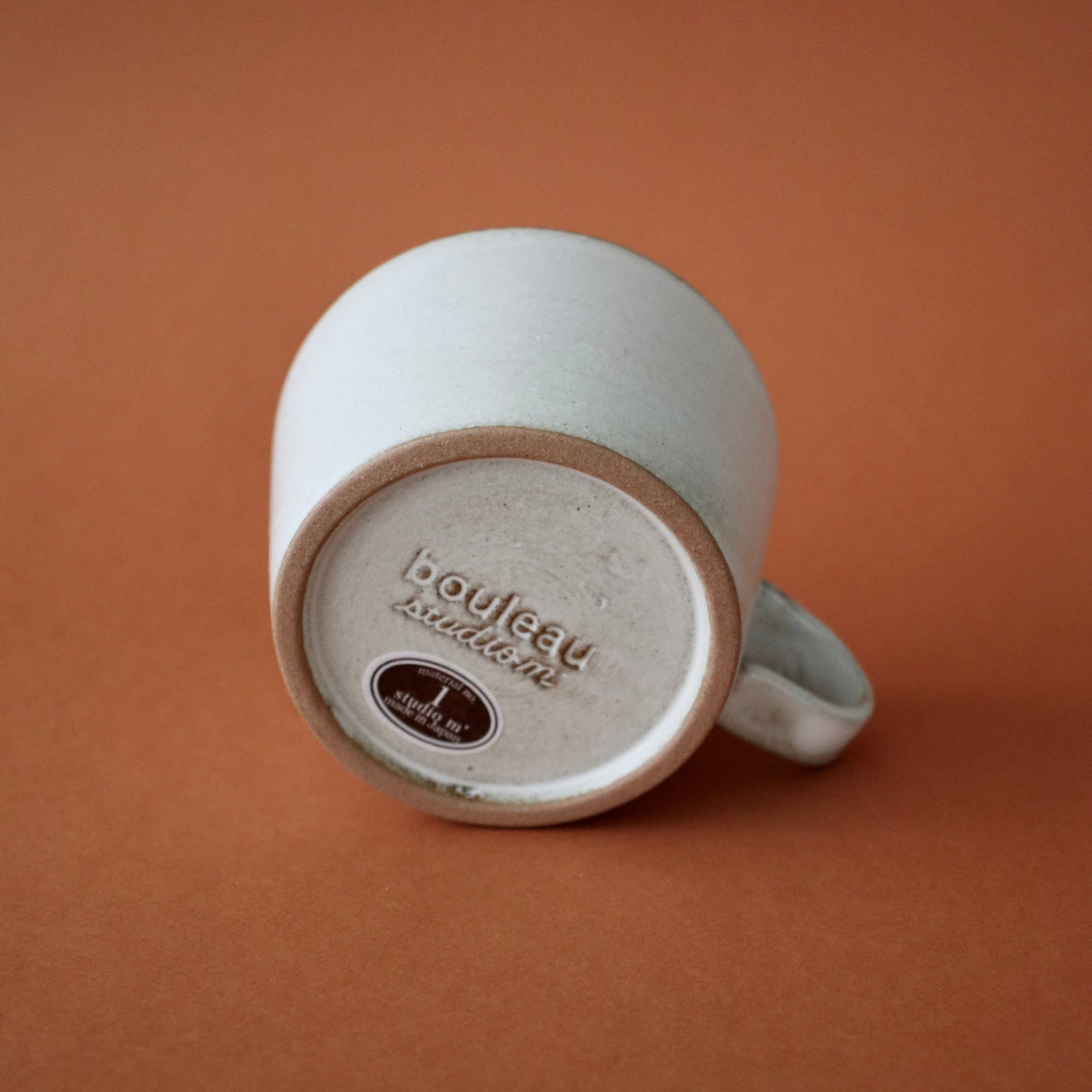 Base of Japanese Ceramic Birch Cup against orange backdrop.