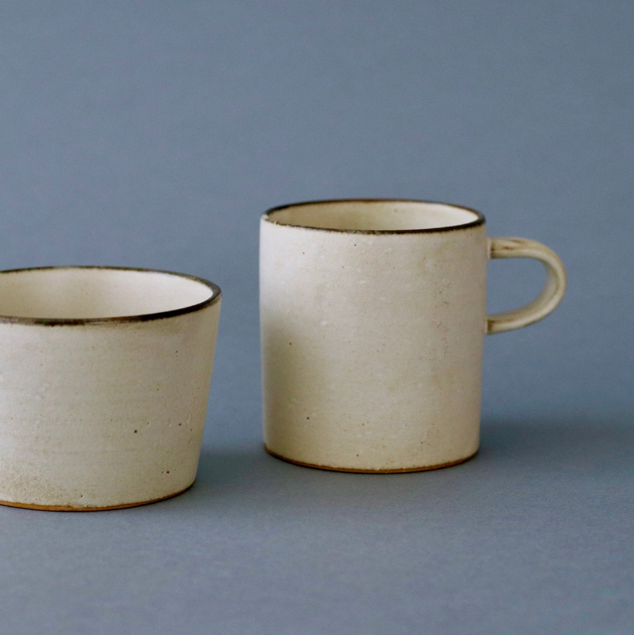 Japanese Ceramic Birch tall and low cups against blue backdrop.