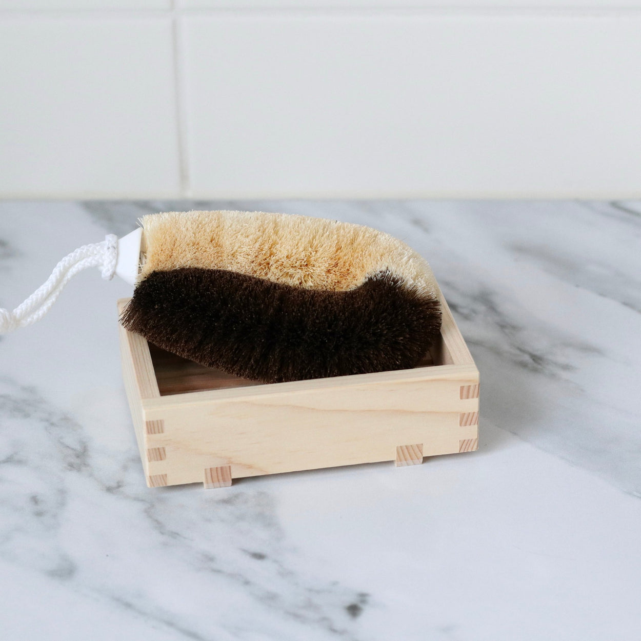 Japanese two toned natural body scrub brush in hinoki soap dish on marble bench top
