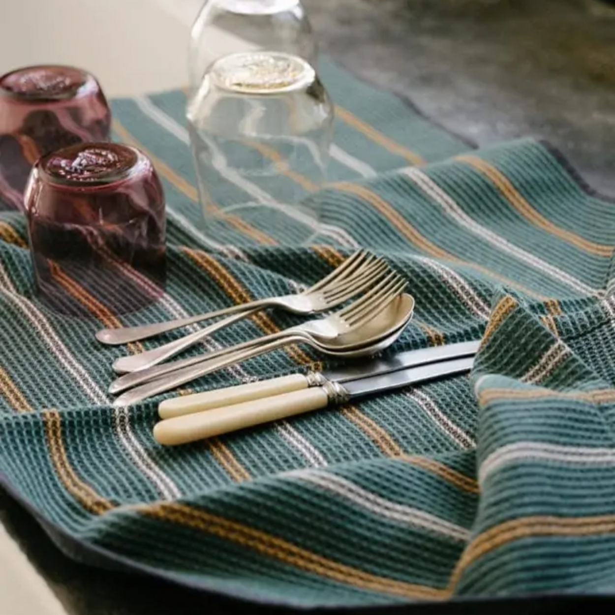 Mungo Waffle Tea Towel in Junipe Green on vintage table with vintage cutlery.