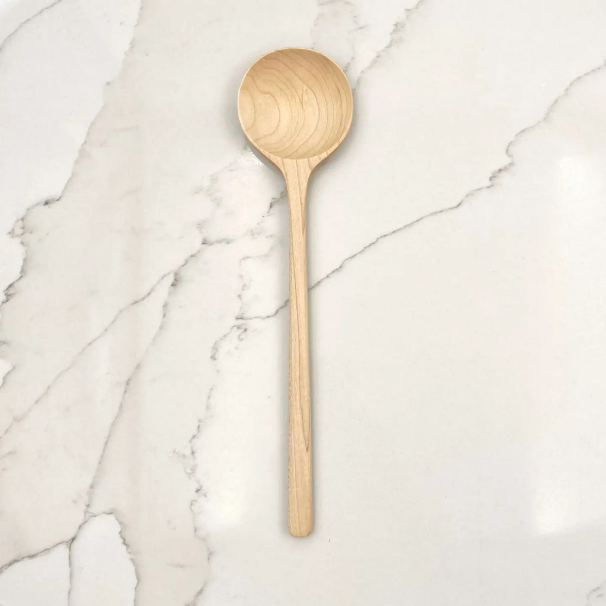 Hand crafted maple wood spoon on marble benchtop