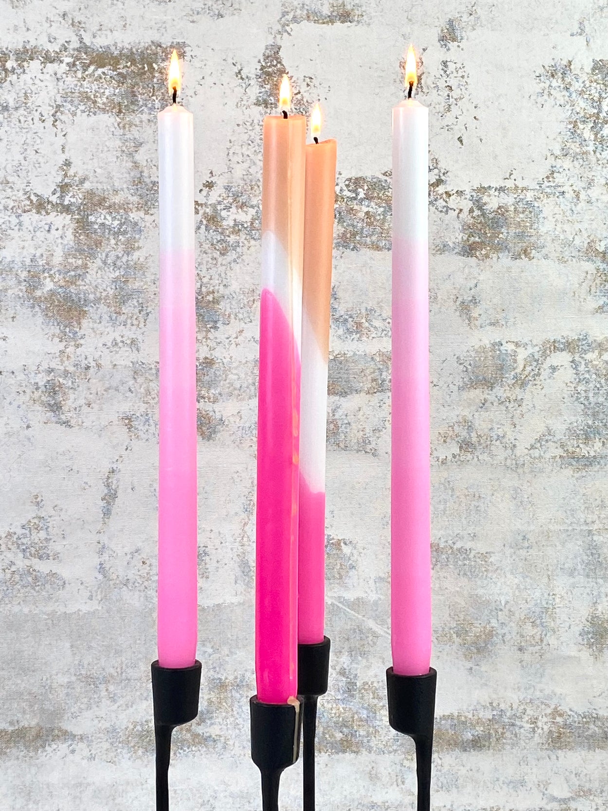 Lit Pink Ombre Candles Pair with pink splash candles on black candleholder on white distressed background