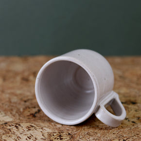 Handmade Ceramic Coffee Mug - Large by Richard Beauchamp lying down on cork background.