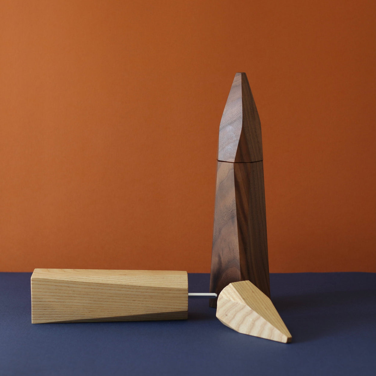 Walnut Wood Pepper Grinder by Martino Gamper, Salt Grinder lying on side in front.