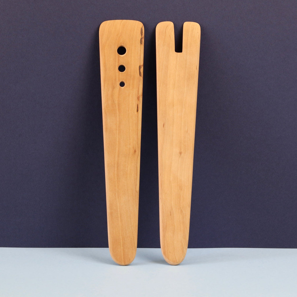 Handmade Pear Wood Salad Servers upright against a blue background