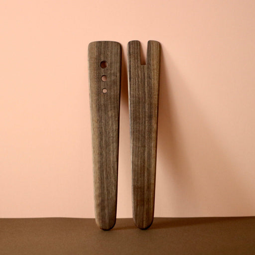 Handmade Walnut Wood Salad Servers upright against a peach and chocolate background. By Civil Dawn Studio.