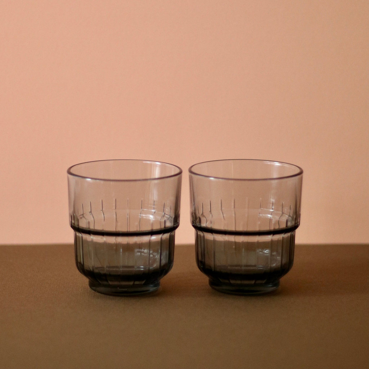 Smoky Grey Portuguese glasses x 2 with brown and peach background.
