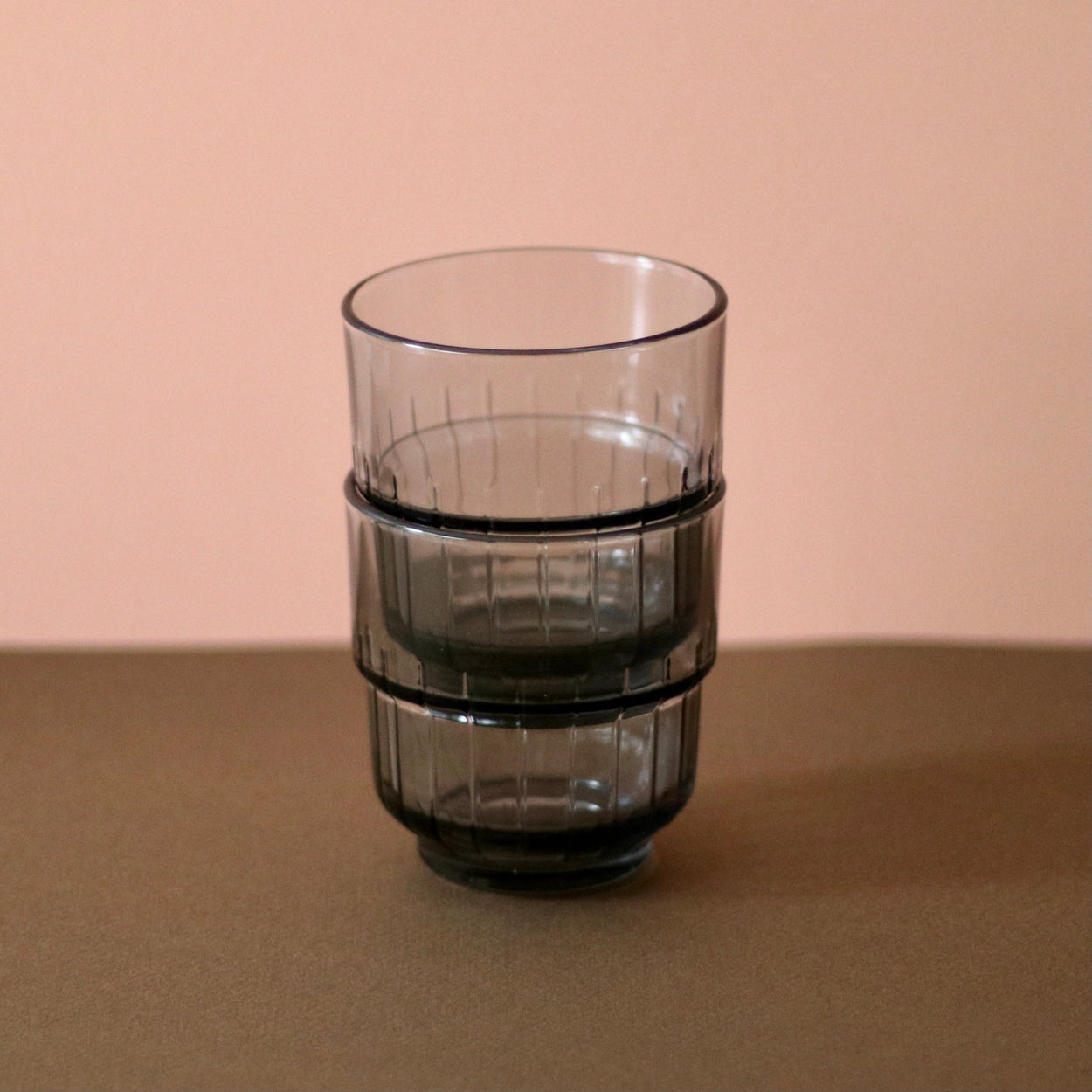 Smoky Grey Portuguese glasses x 2 stacked inside each other, with brown and peach background.