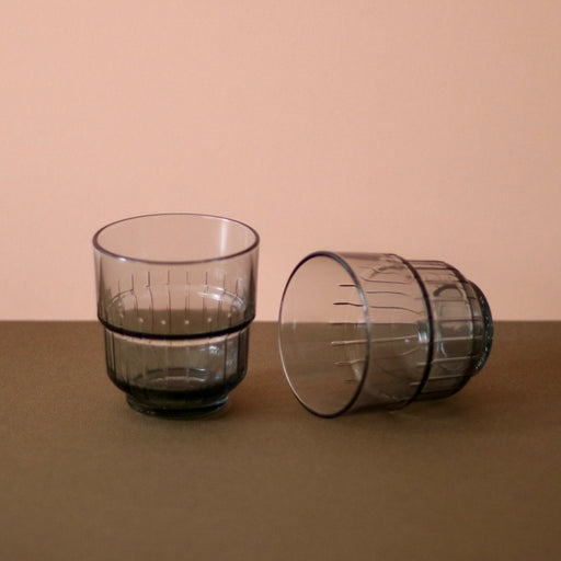 Smoky Grey Portuguese glasses x 2, one lying on it's side with brown and peach background.