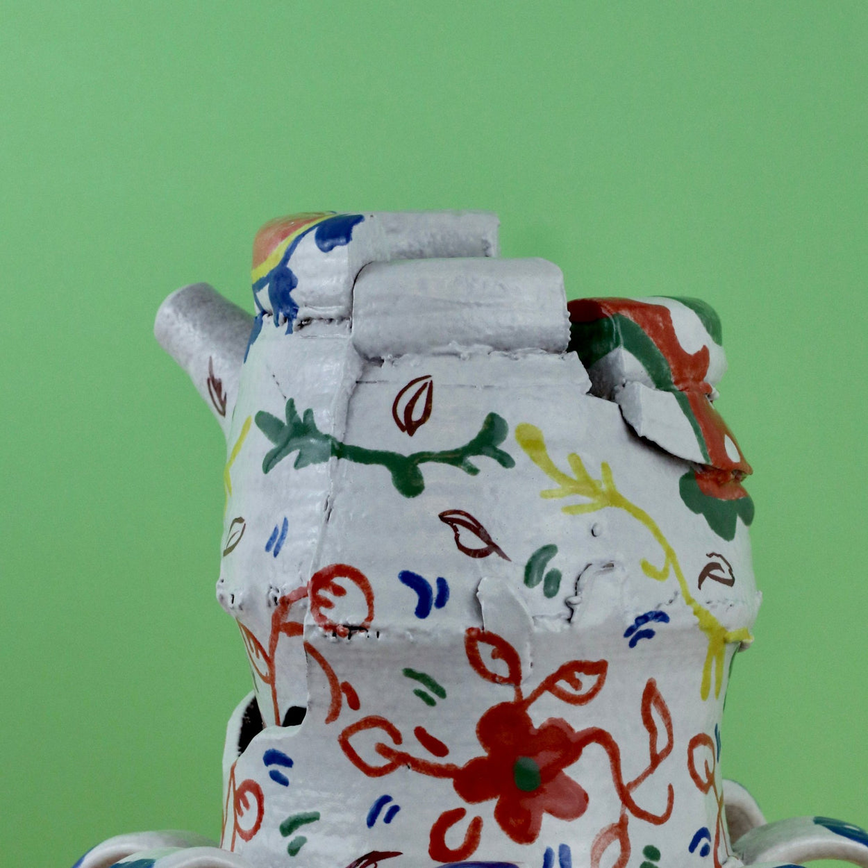 Handmade Ceramic Pentref Jug by Elin Hughes against a green and peach background. Back close up.