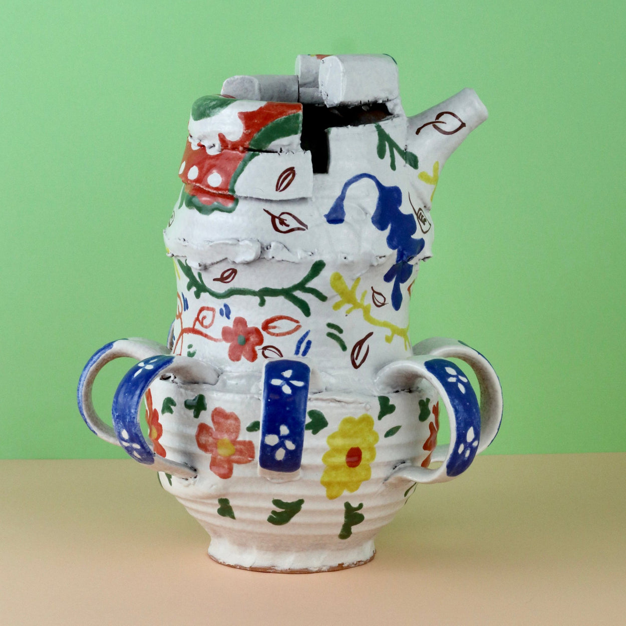 Handmade Ceramic Pentref Jug by Elin Hughes against a green and peach background.