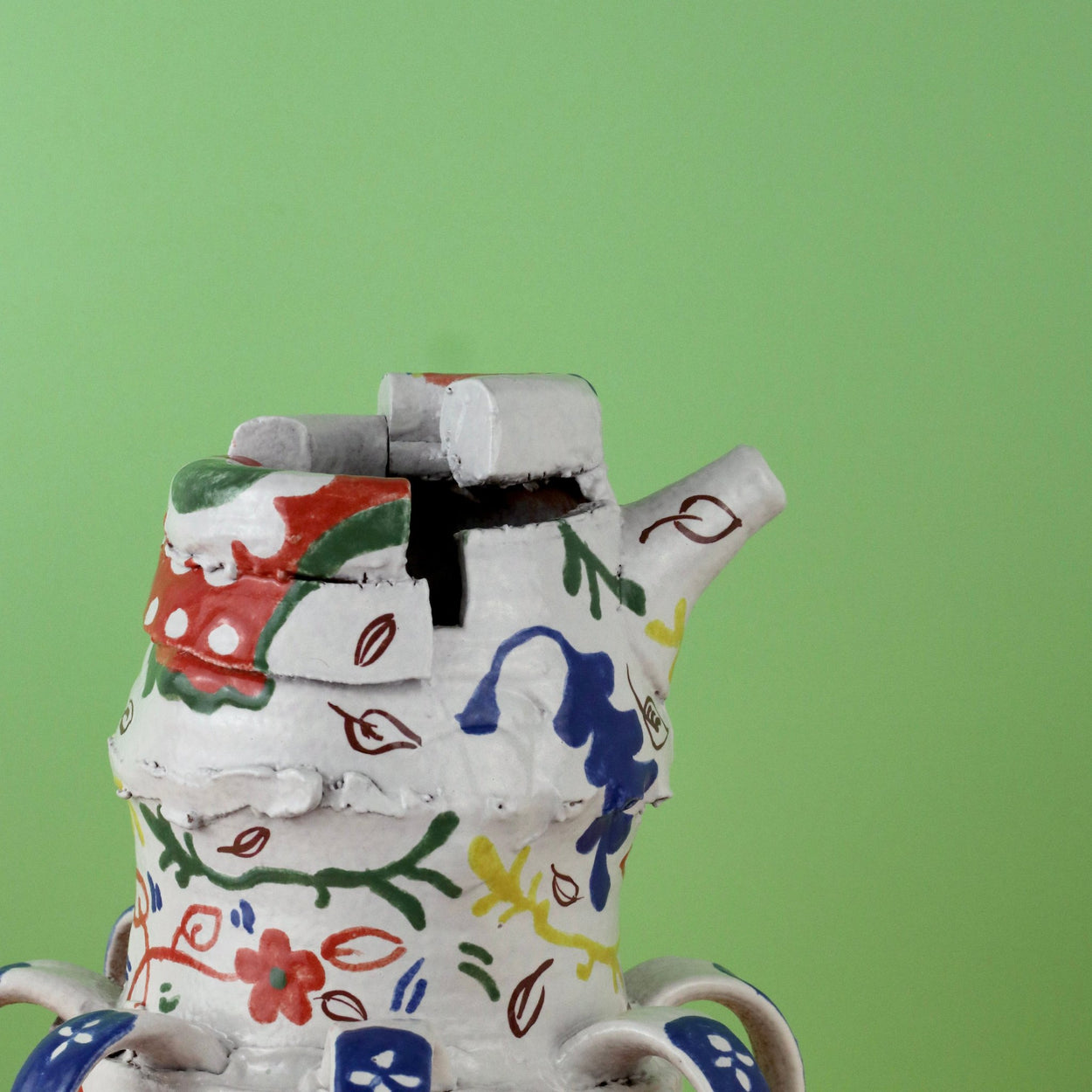 Handmade Ceramic Pentref Jug by Elin Hughes against a green and peach background. Side top view.