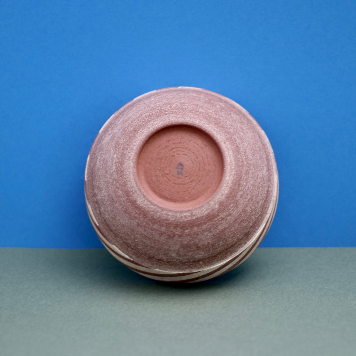 Ceramic Thin Stripe Bowl by Amanda-Sue Rope with blue green background. Base view with Makers Mark.