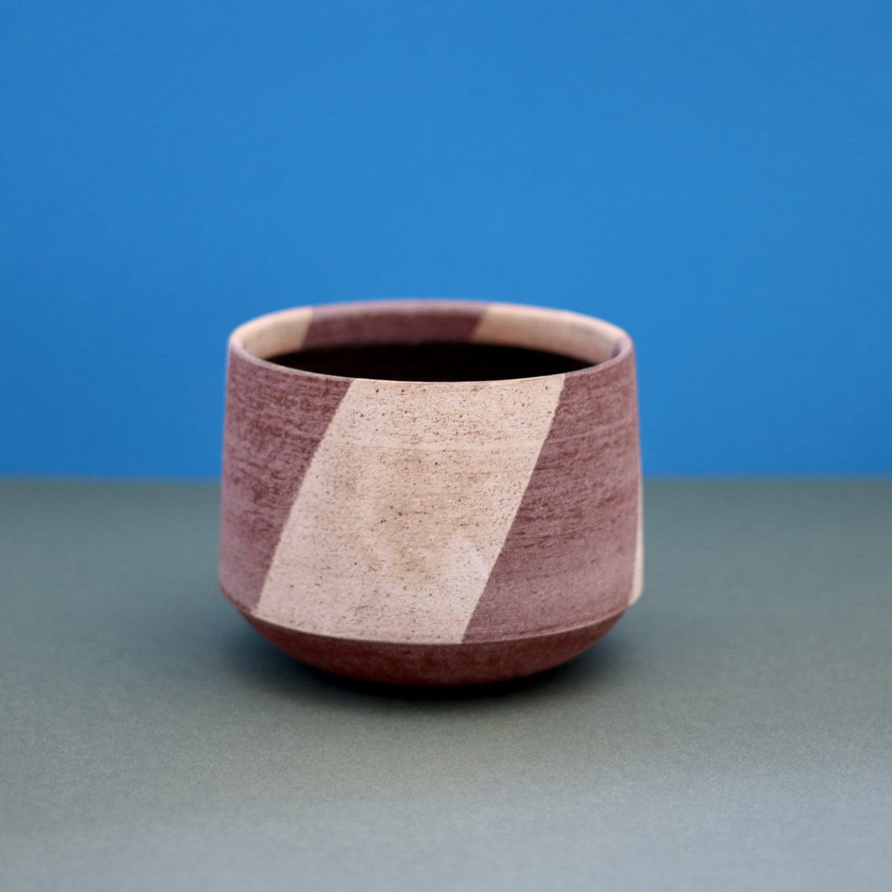 Ceramic Stripe Bowl by Amanda-Sue Rope with blue green background.