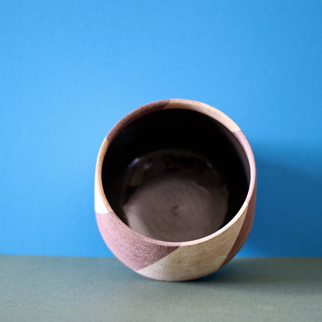 Ceramic Stripe Bowl by Amanda-Sue Rope with blue green background. Interior view