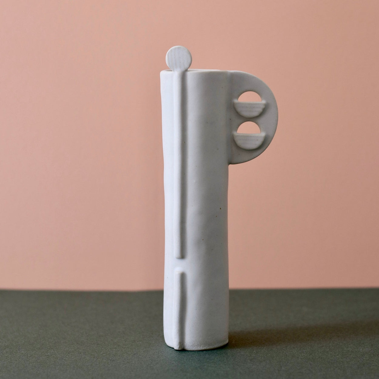 Cassie Hansen Tall Vase against green and peach background, front view.
