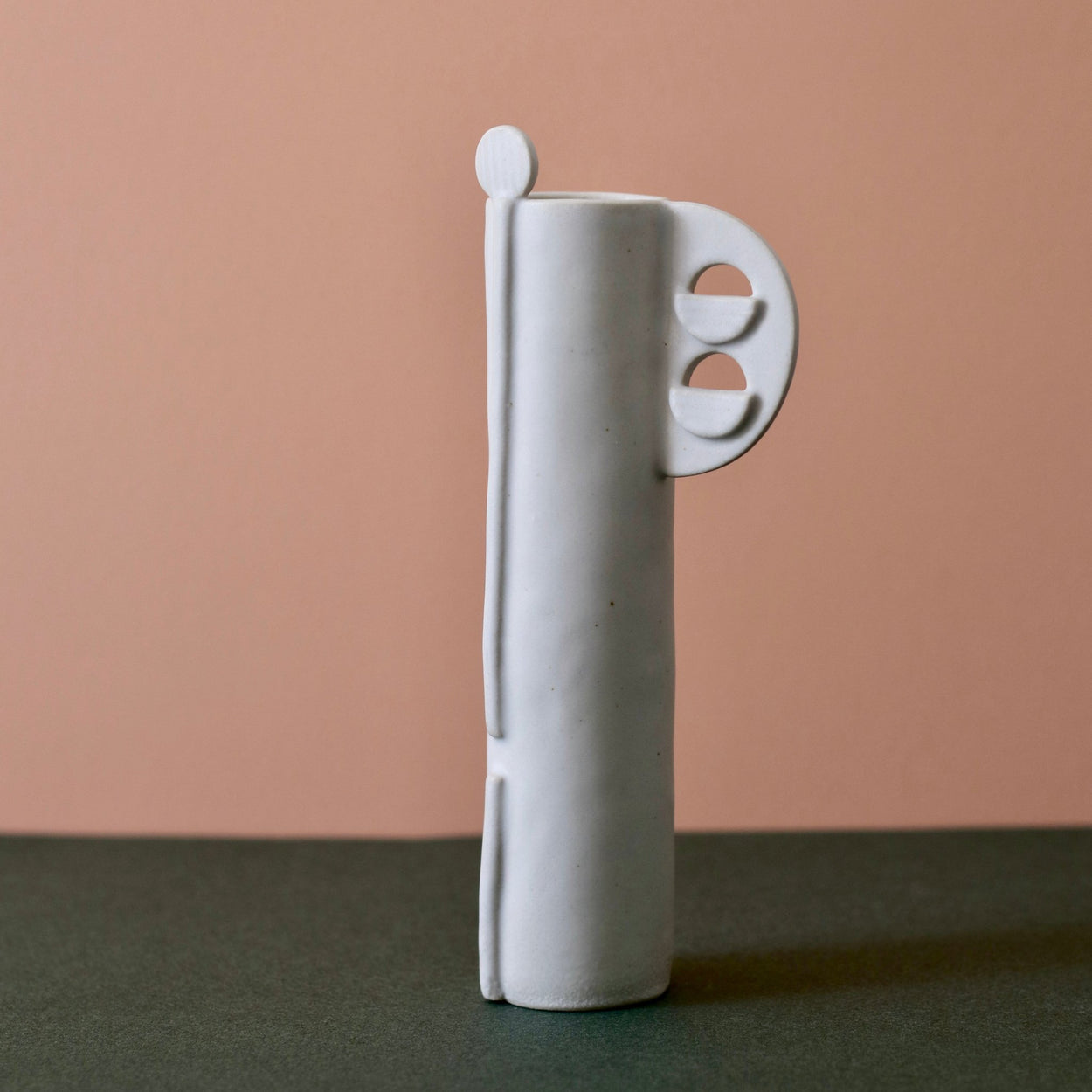 Cassie Hansen Tall Vase against green and peach background, front view.