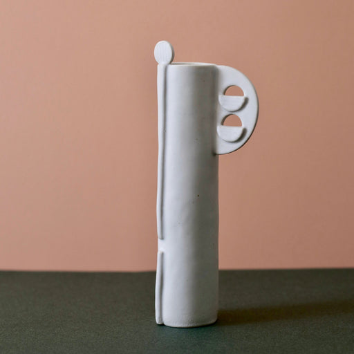 Cassie Hansen Tall Vase against green and peach background, front view.