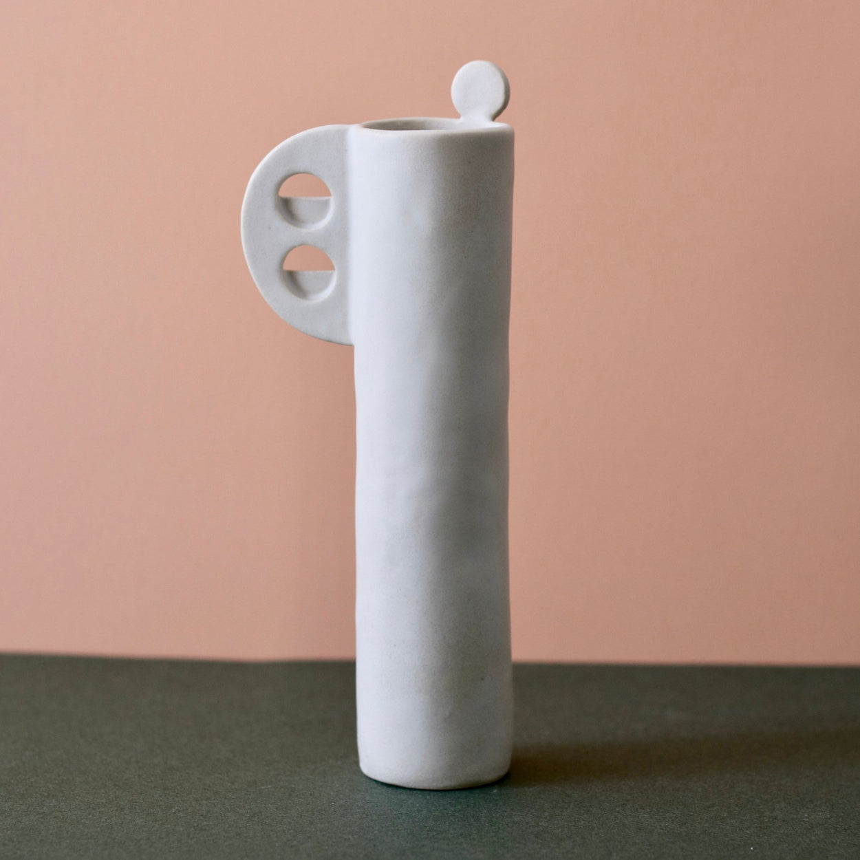 Cassie Hansen Tall Vase against green and peach background, back view.
