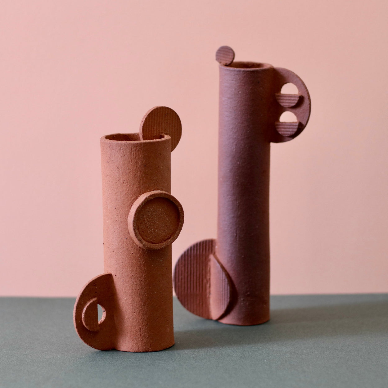 Two Cassie Hansen Tall Sculpture against a green and peach background.
