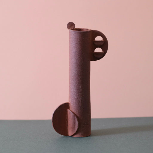 Cassie Hansen Tall Sculpture against a green and peach background.