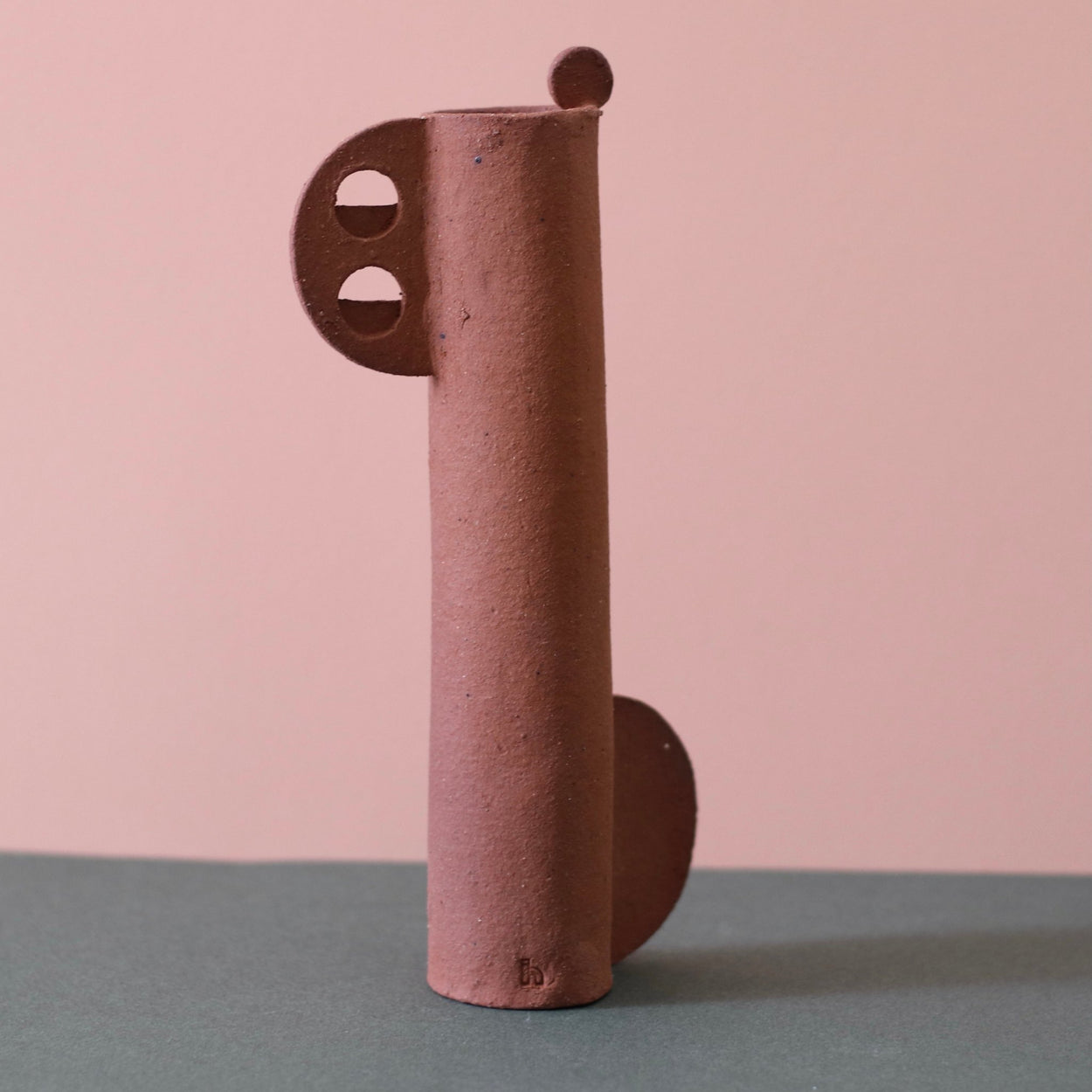 Cassie Hansen Tall Sculpture against a green and peach background.