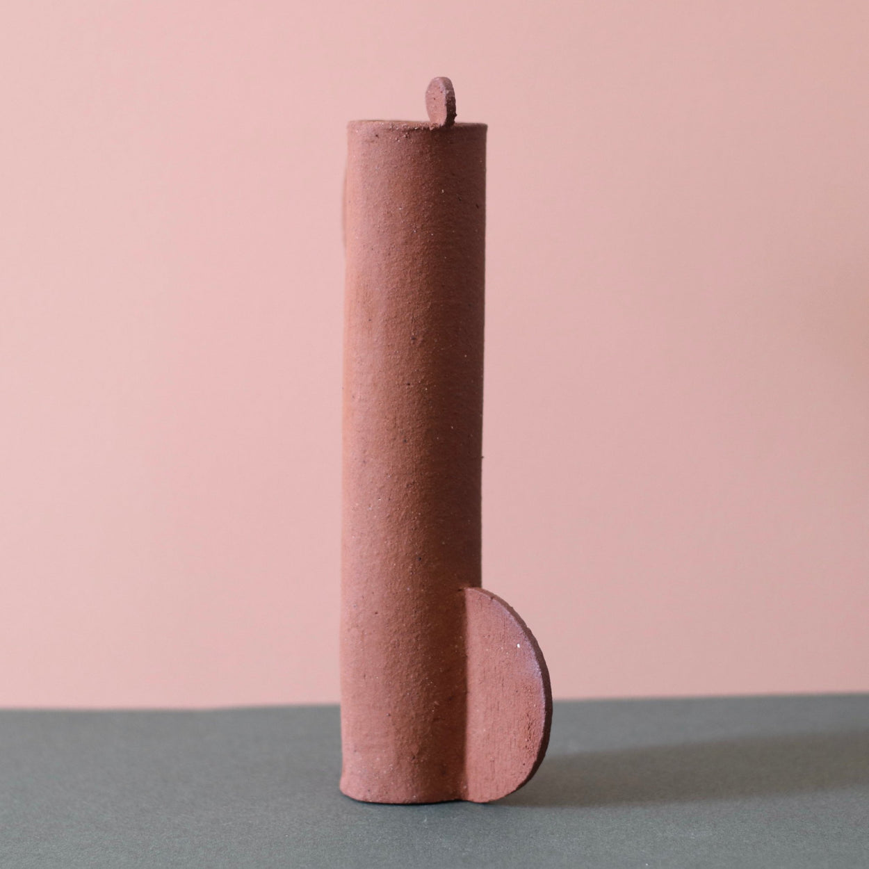 Cassie Hansen Tall Sculpture against a green and peach background. Back view