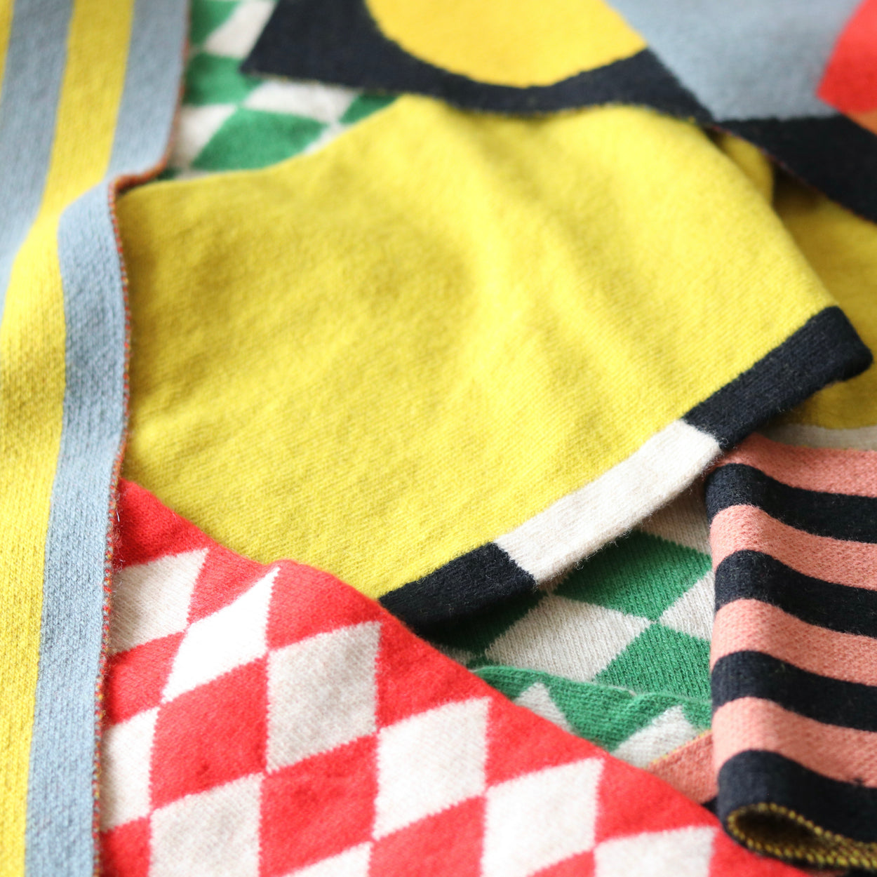 Assorted colourful Jo Gordon scarves criss crossed on top of each other.