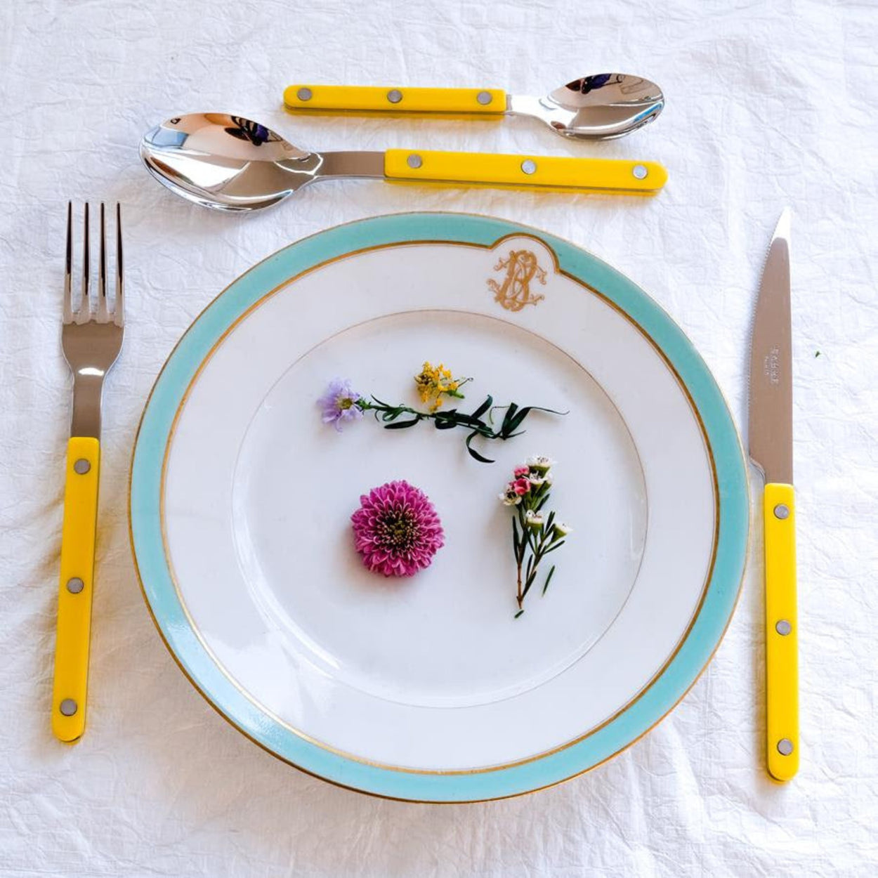 Sabre Paris Bistrot Yellow Flatware 4 Piece Set with white and blue dinner plate with flowers