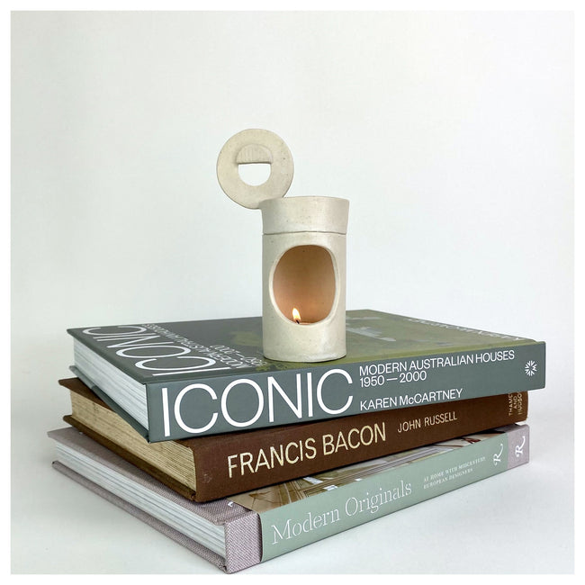 Cassie Hansen ceramic oil burner on top of a pile of books.