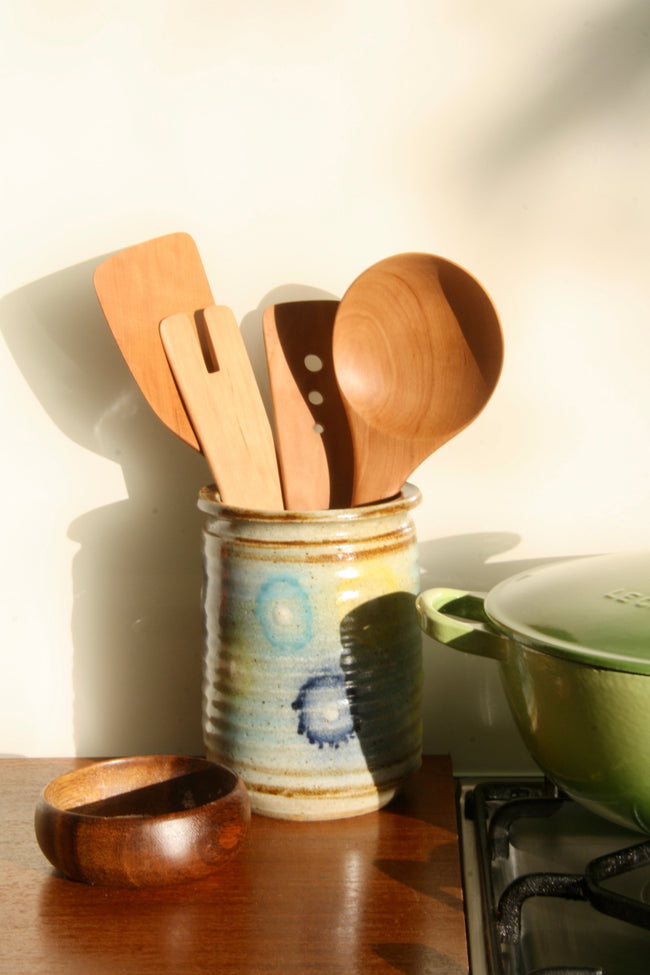 Esen Wood kitchen utensils in ceramic pot on kitchen bench.