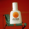 Standard Procedure sunscreen on a fold out camp chair against a red background.