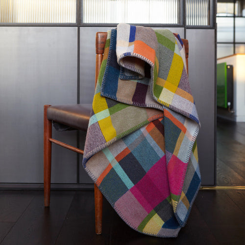 Wallace Sewell Gwynne Block Blanket draped over chair in modern house setting.