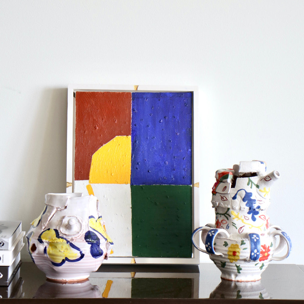 A Apir of colourful Elin Hughes jugs in front of a colourful painting.