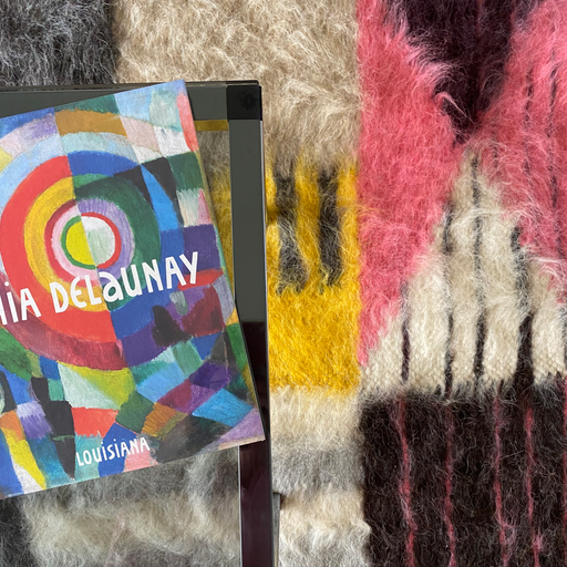 A bright Bauhaus wool shag rug with Sonia Delaunay book on a coffee table