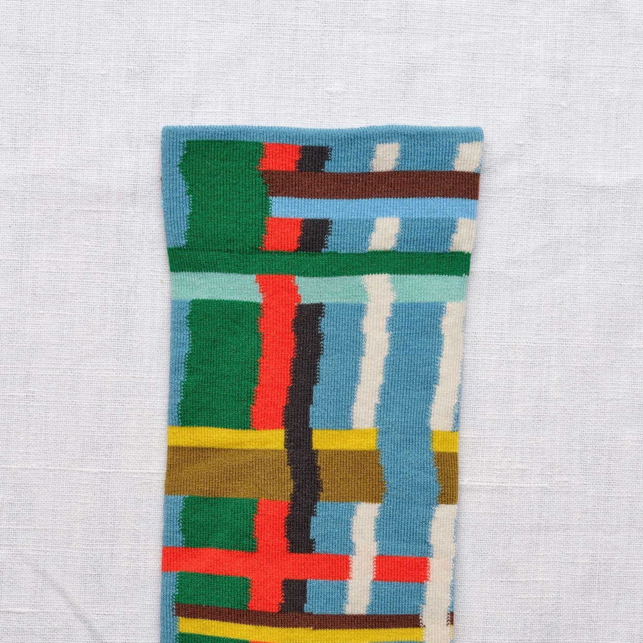 close up of Bonne Maison Blue Grid socks on white backdrop.