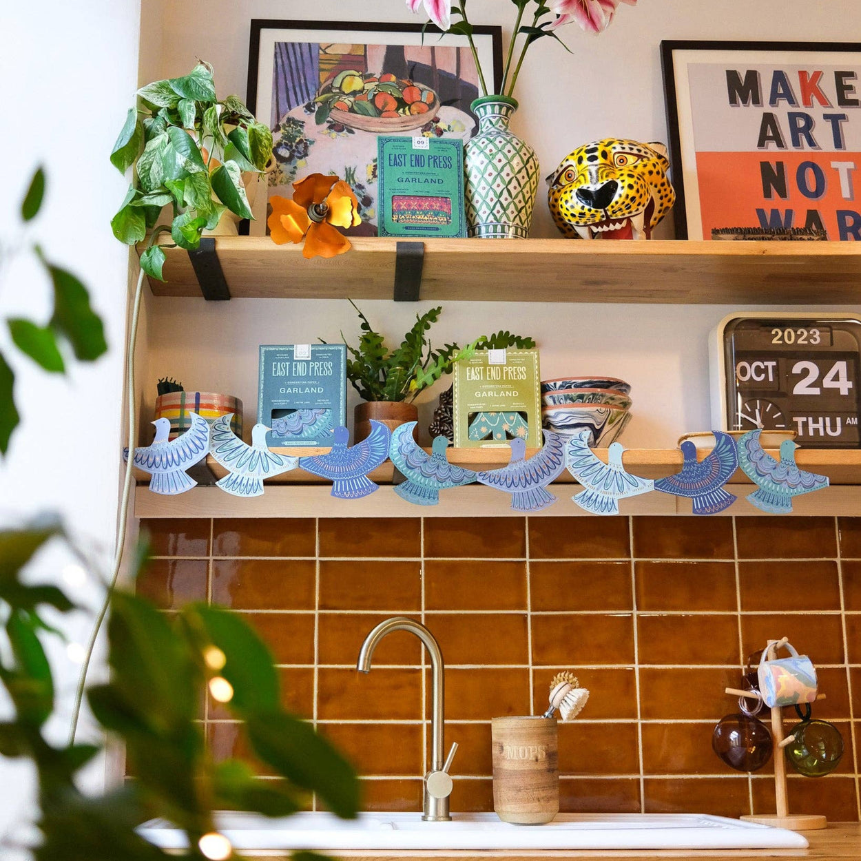 Kitchen counter with decorative items, plants, and a calendar.